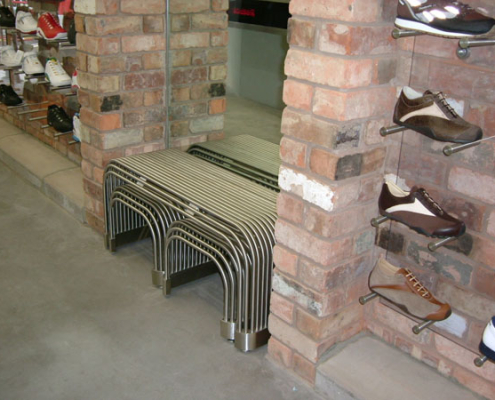 An industrial style metal bench made from bent tubes and pipes.