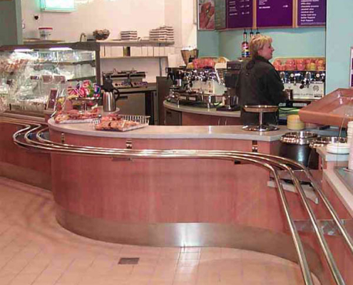 A catering counter with shaped pipe railings for trays to move along